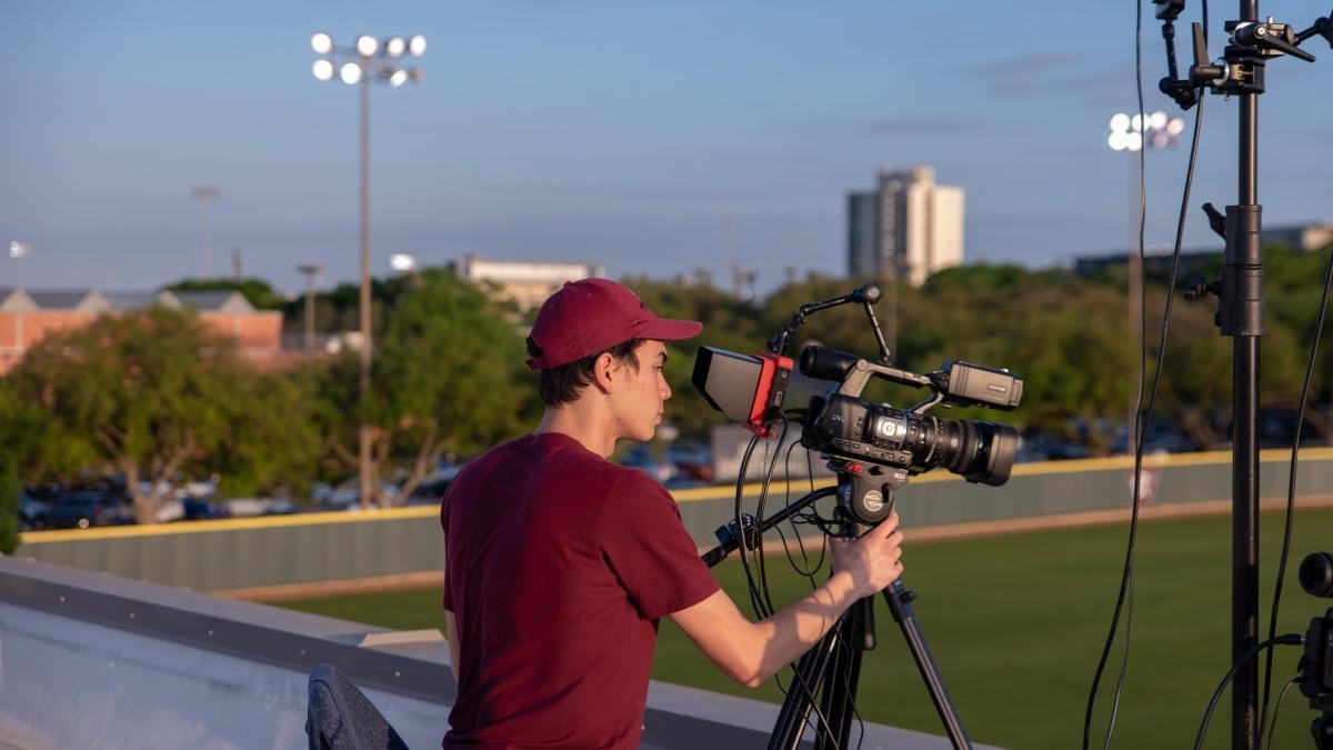 A student films an event on Trinity's campus